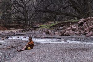 Niño junto al río en Magdaz, Marruecos
